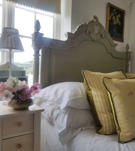French bed with Little Pink roses on yellow linen cushions by rose and foxgloves